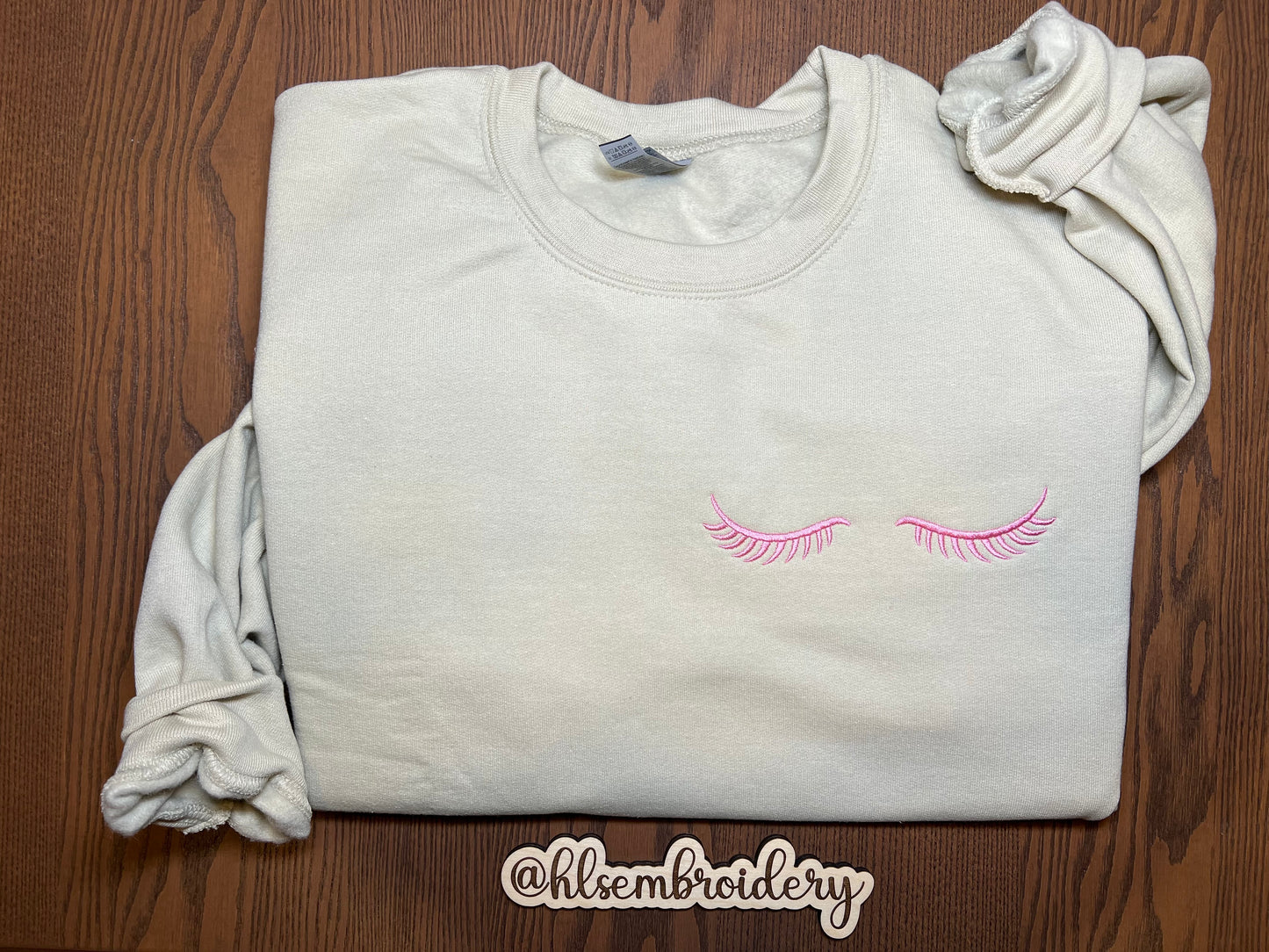 Sand color crewneck with lashes embroidered.
