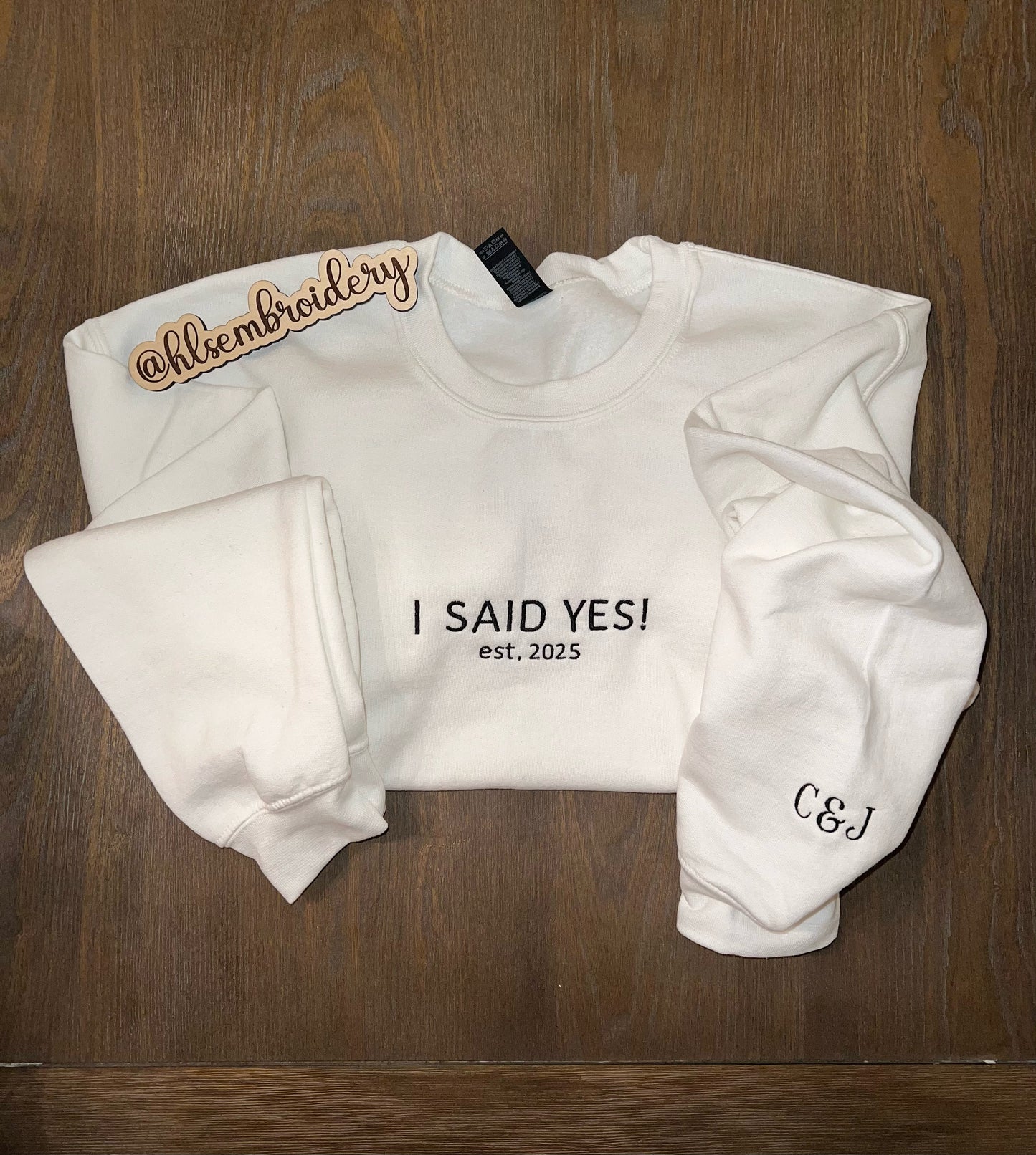 White crewneck with embroidery "i said yes!" and sleeve embroidery.