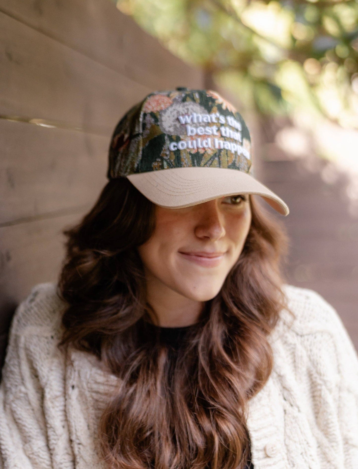 Person wearing a floral-patterned cap with text "What's the best could happen"