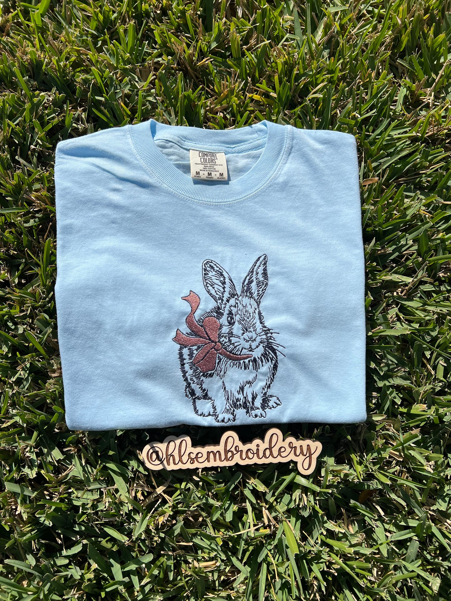 Light blue shirt with bunny and bow embroidered on the front.