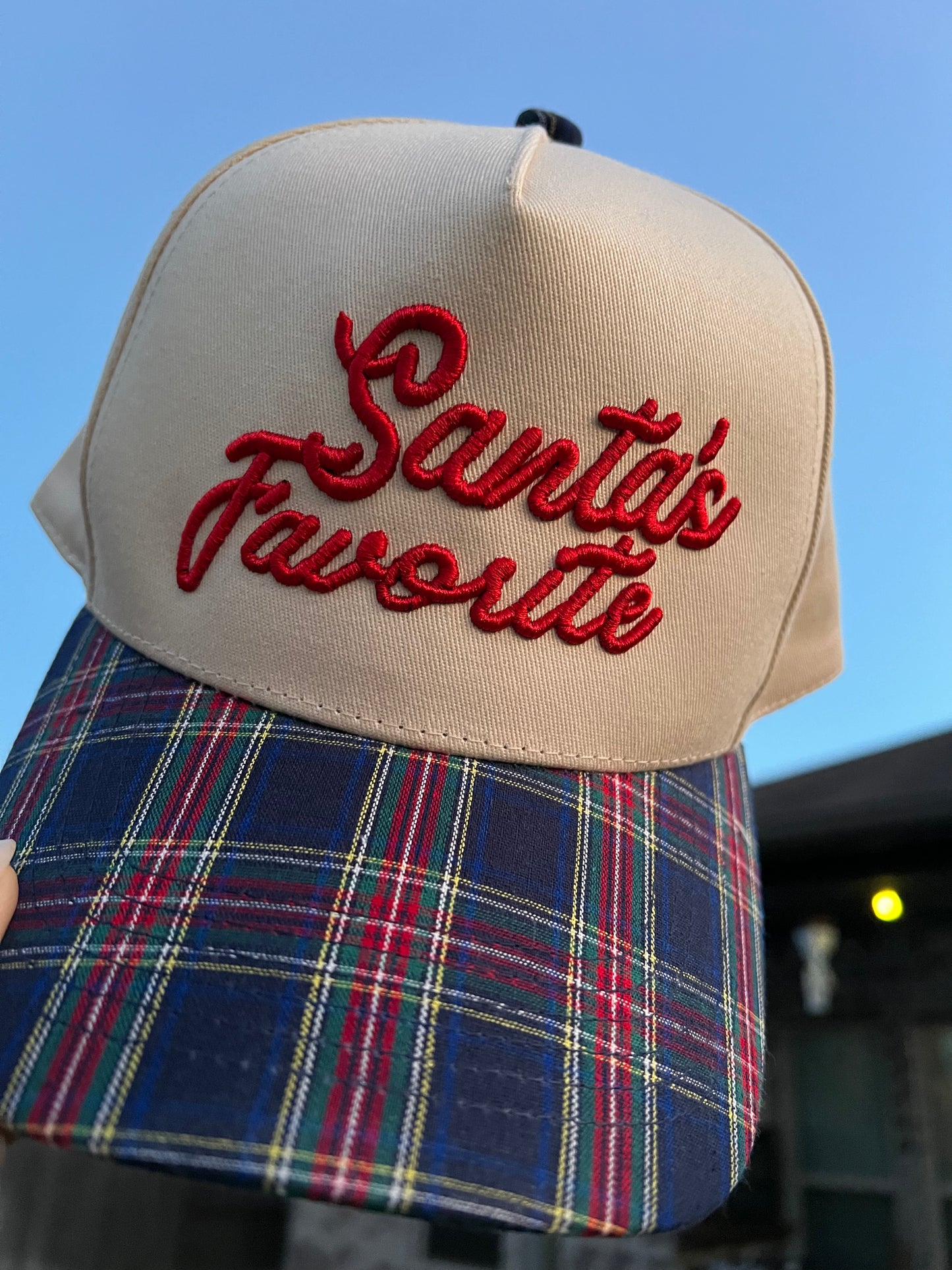 beige and plaid cap with puff embroidery with the text "Santa's Favorite"