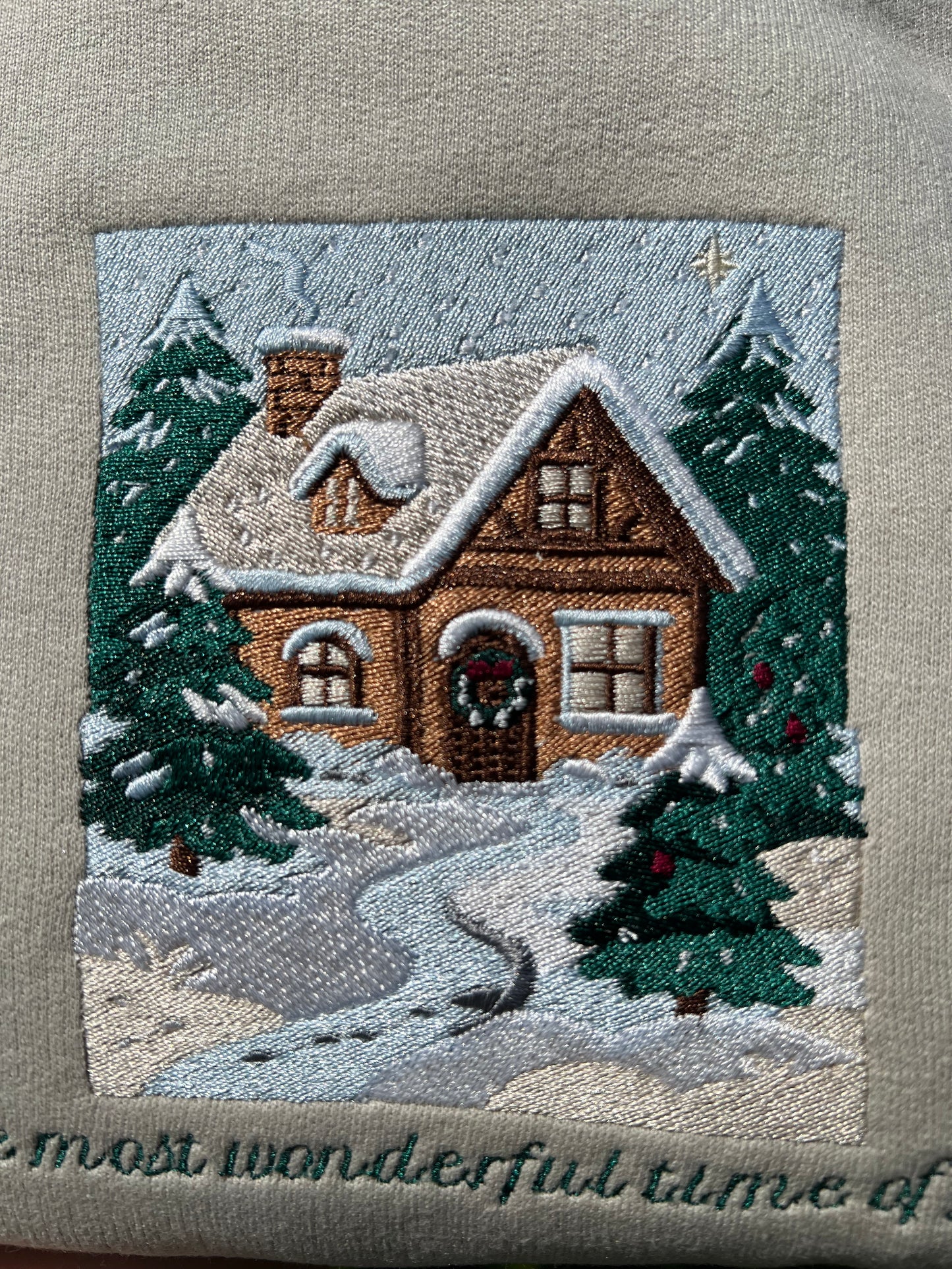 Embroidered Crewneck -with the words "The most wonderful time of year below a snowy scenic cabin