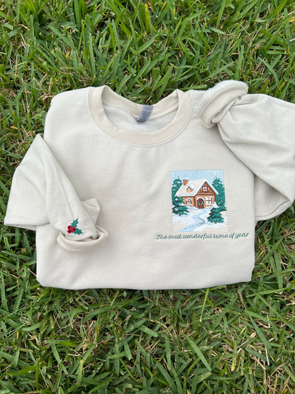 Embroidered Crewneck -with the words "The most wonderful time of year below a snowy scenic cabin