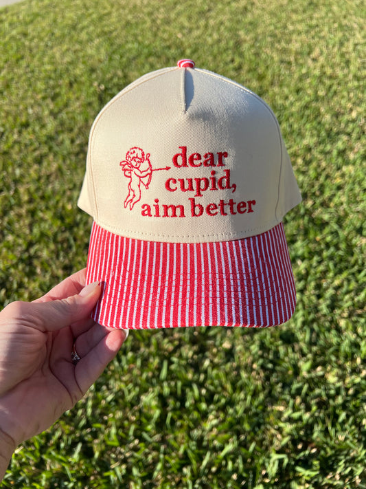 red and white stripe brim with beige Cap with 'dear cupid, aim better' text embroidered 