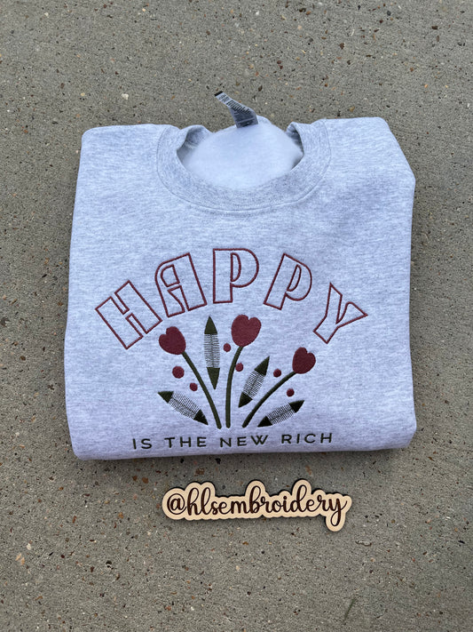 Embroidered crewneck in ash gray with 'Happy is the New Rich' text and floral design Embroidery.