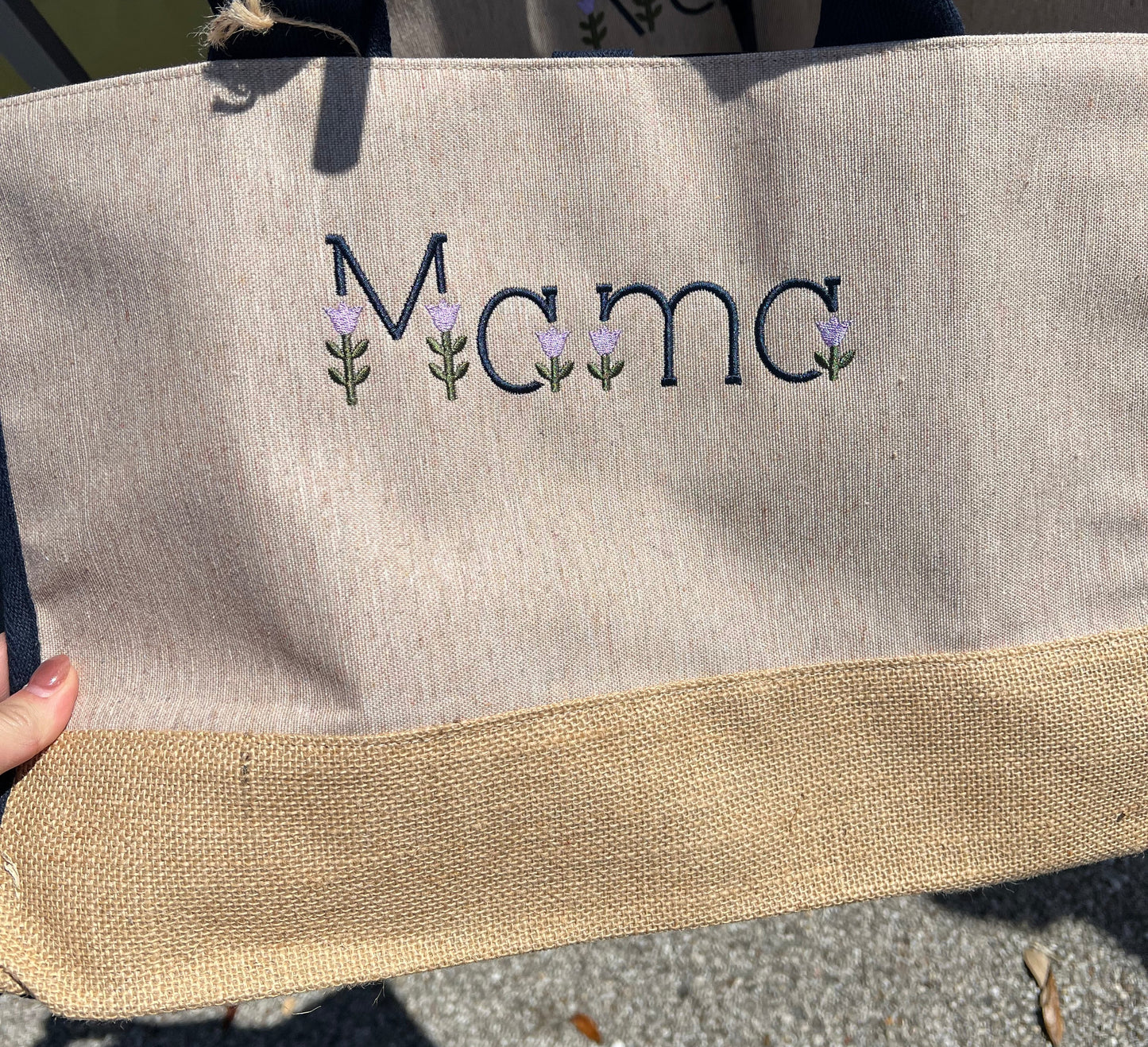 Mama wording in tulip embroidery font on the front of the tote bag