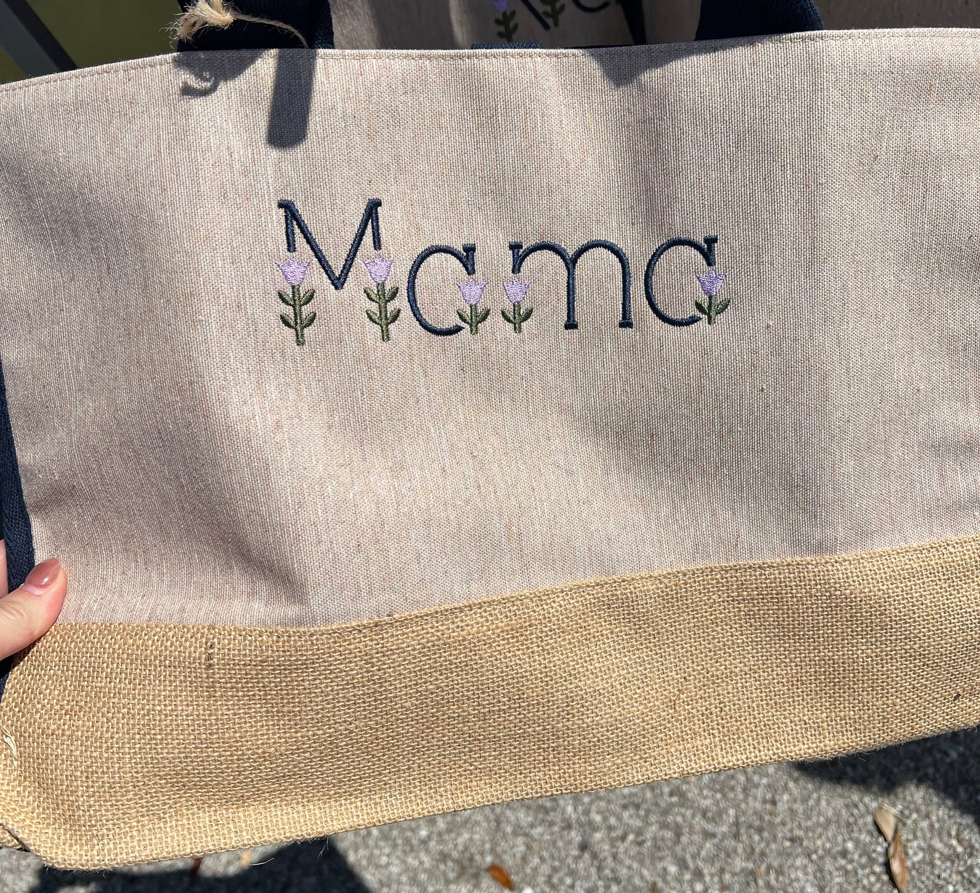 Mama wording in tulip embroidery font on the front of the tote bag