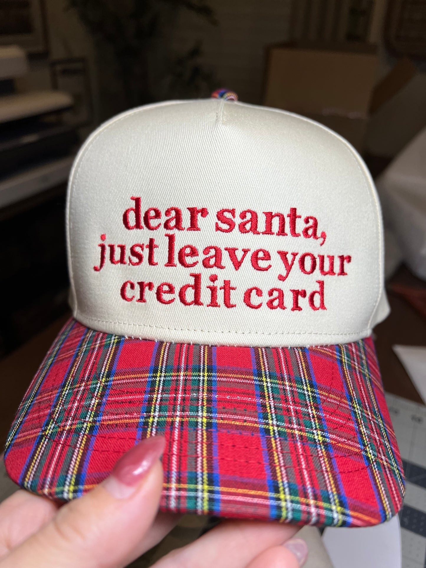 plaid and beige cap with wording on the front in embroidery. 