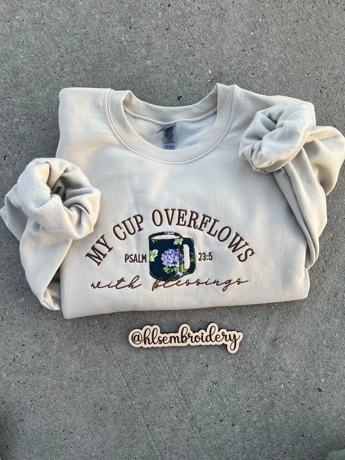 sand color crewneck embroidered using appliqué and regular embroider with text "My cup overflows with blessings" "Psalm 23:5)