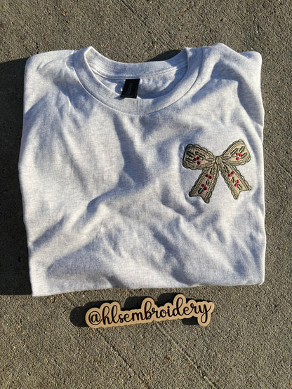 Embroidered bow design on a gray fabric with 'hlsembrodiery' branding.