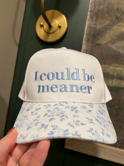 Cap with 'I could be meaner' text on a grass background