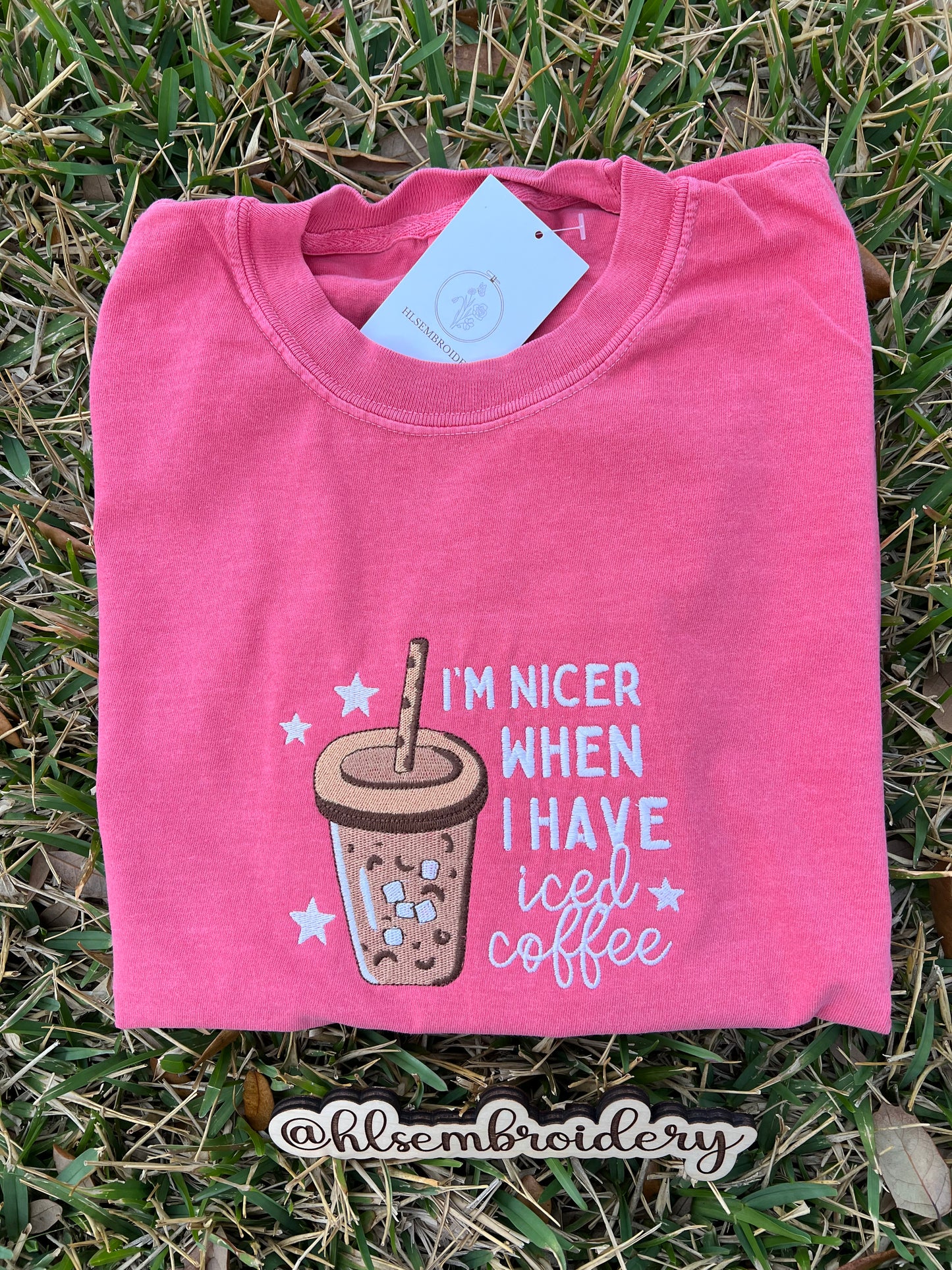 Pink t-shirt with coffee-themed design on grass
