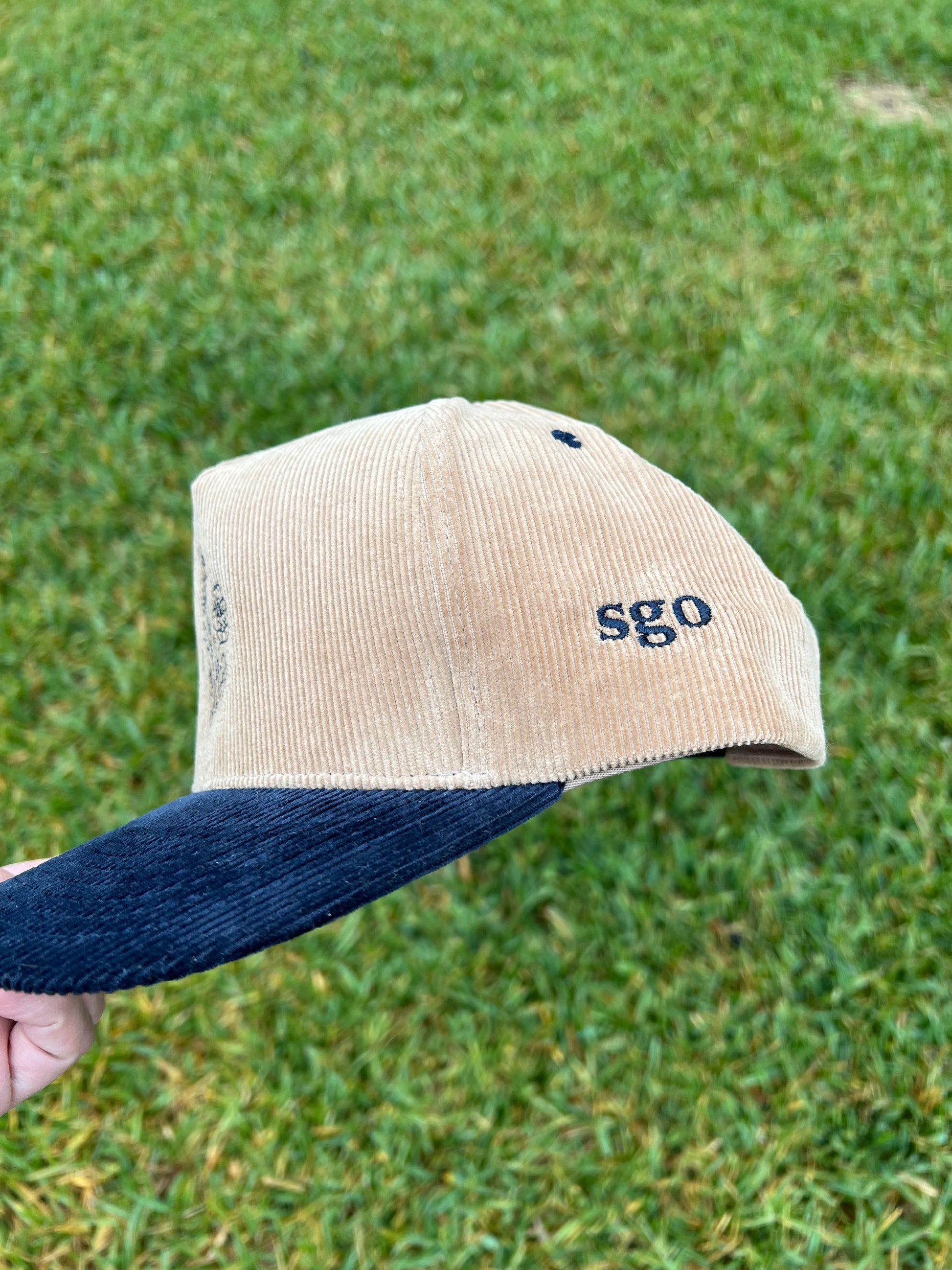 initials embroidered on side of beige and navy corduroy hat 