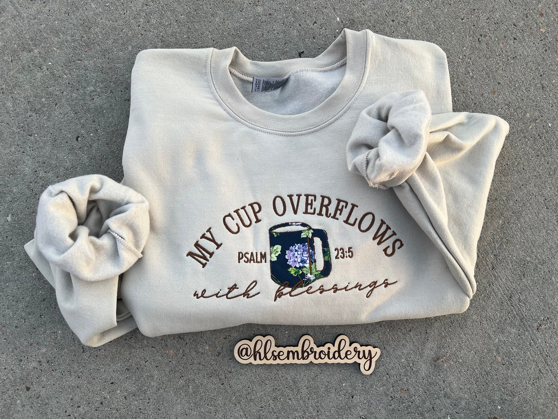 sand color crewneck embroidered using appliqué and regular embroider with text "My cup overflows with blessings" "Psalm 23:5)