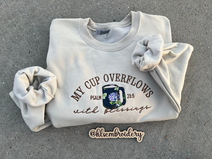 sand color crewneck embroidered using appliqué and regular embroider with text "My cup overflows with blessings" "Psalm 23:5)