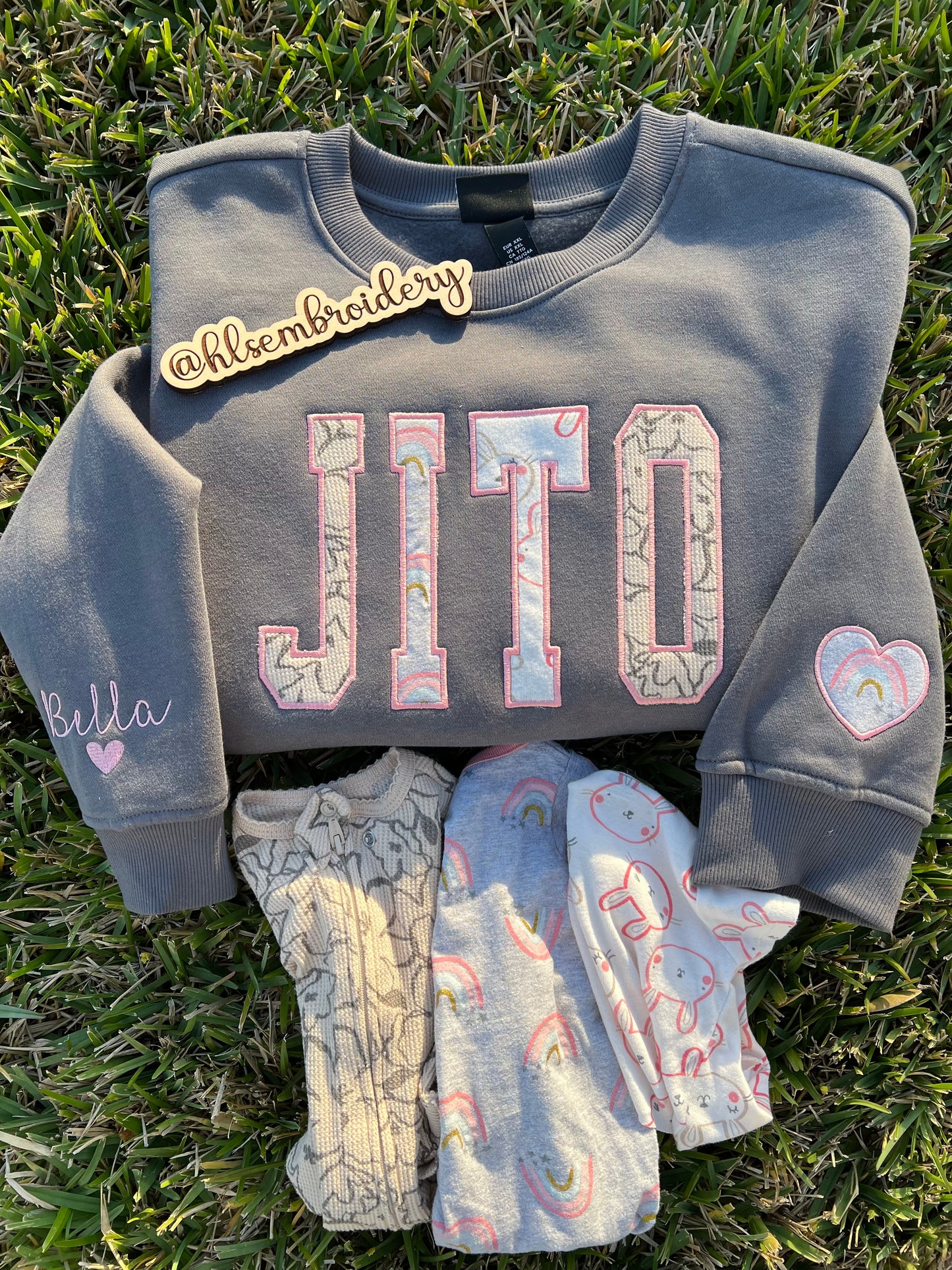Custom name embroidered crewneck using baby clothing and sleeve embroidered detail. 