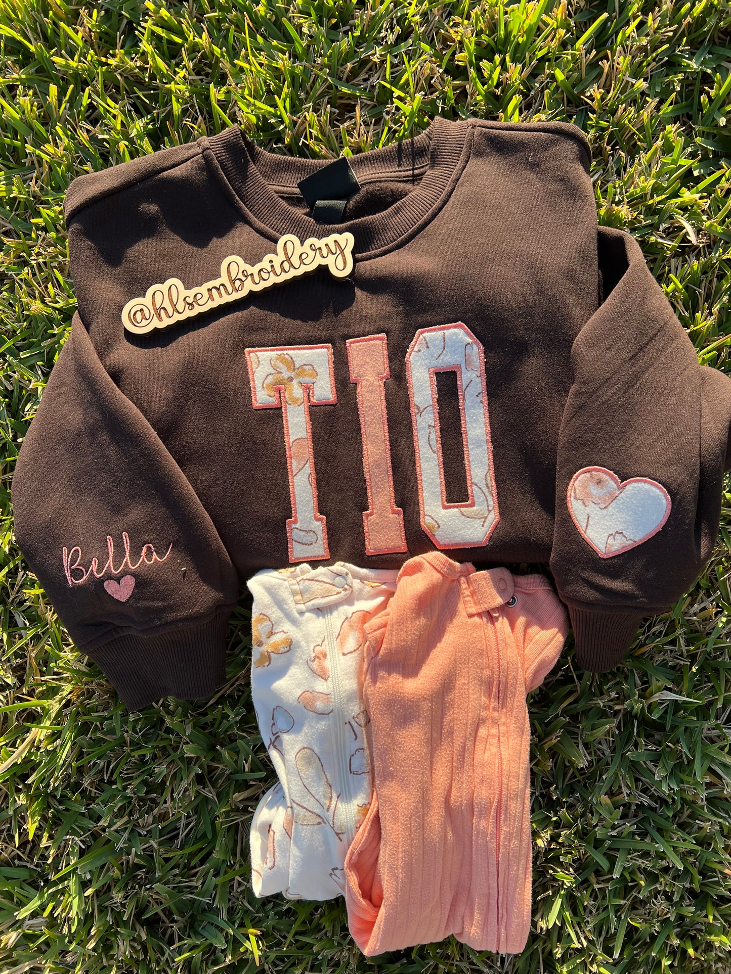 "Tio"embroidered crewneck using baby clothing and sleeve embroidered detail. 