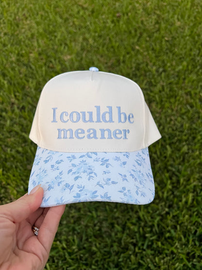 Cap with 'I could be meaner' text on a grass background