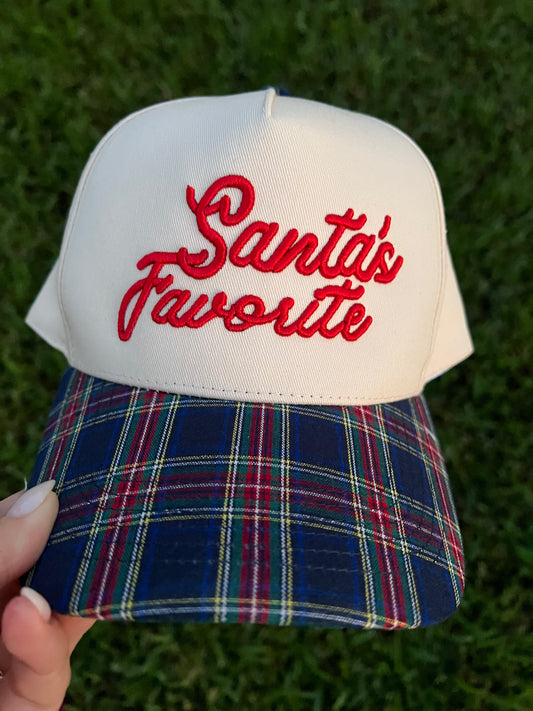 beige and plaid cap with puff embroidery with the text "Santa's Favorite"