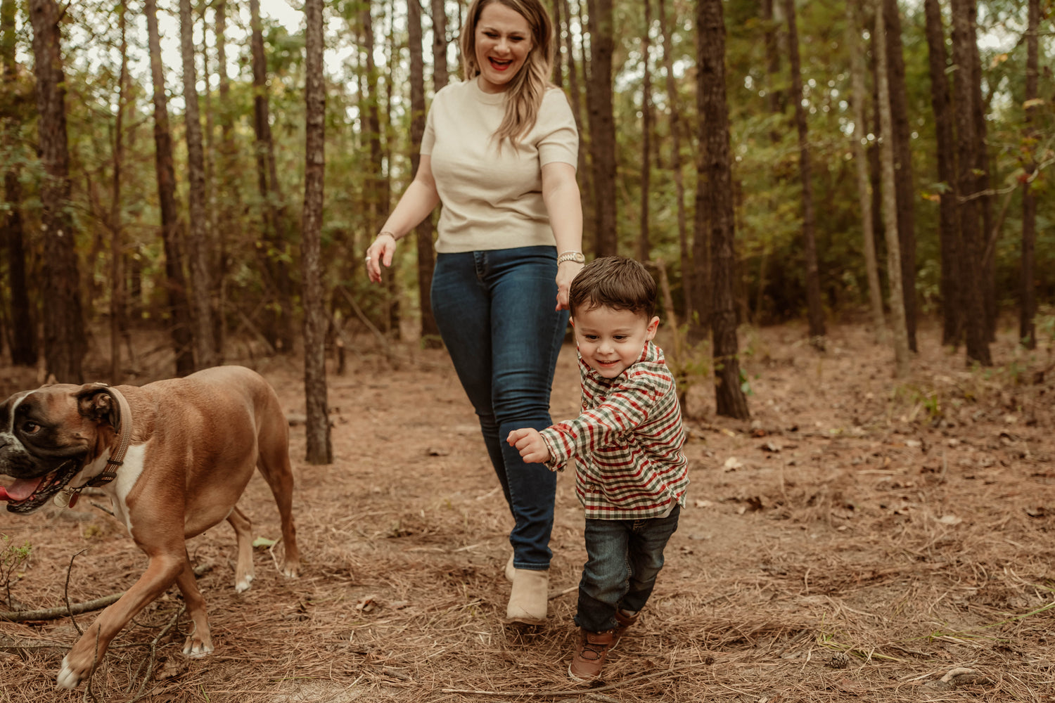 Woman and child walking with a dog in  woods