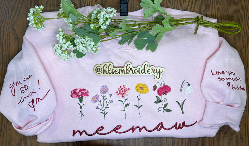 light pink crewneck with handwriting design examples on both sleeves. 