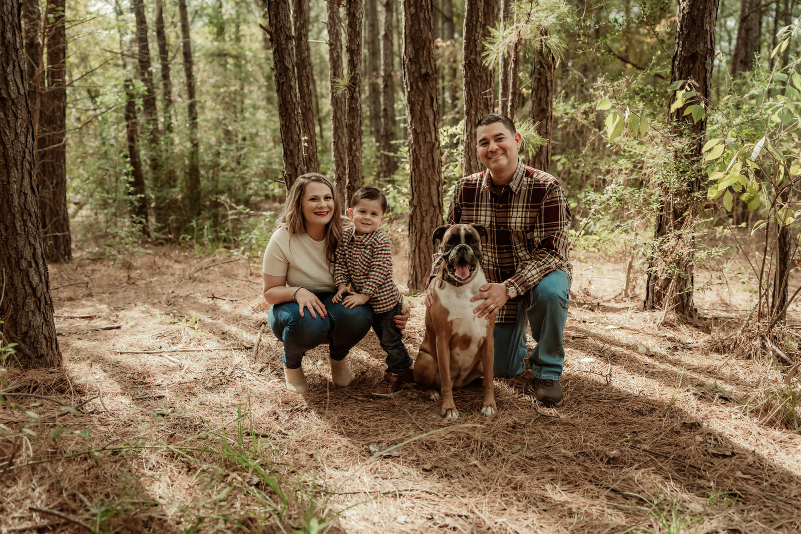  Family of three with a dog in woods setting