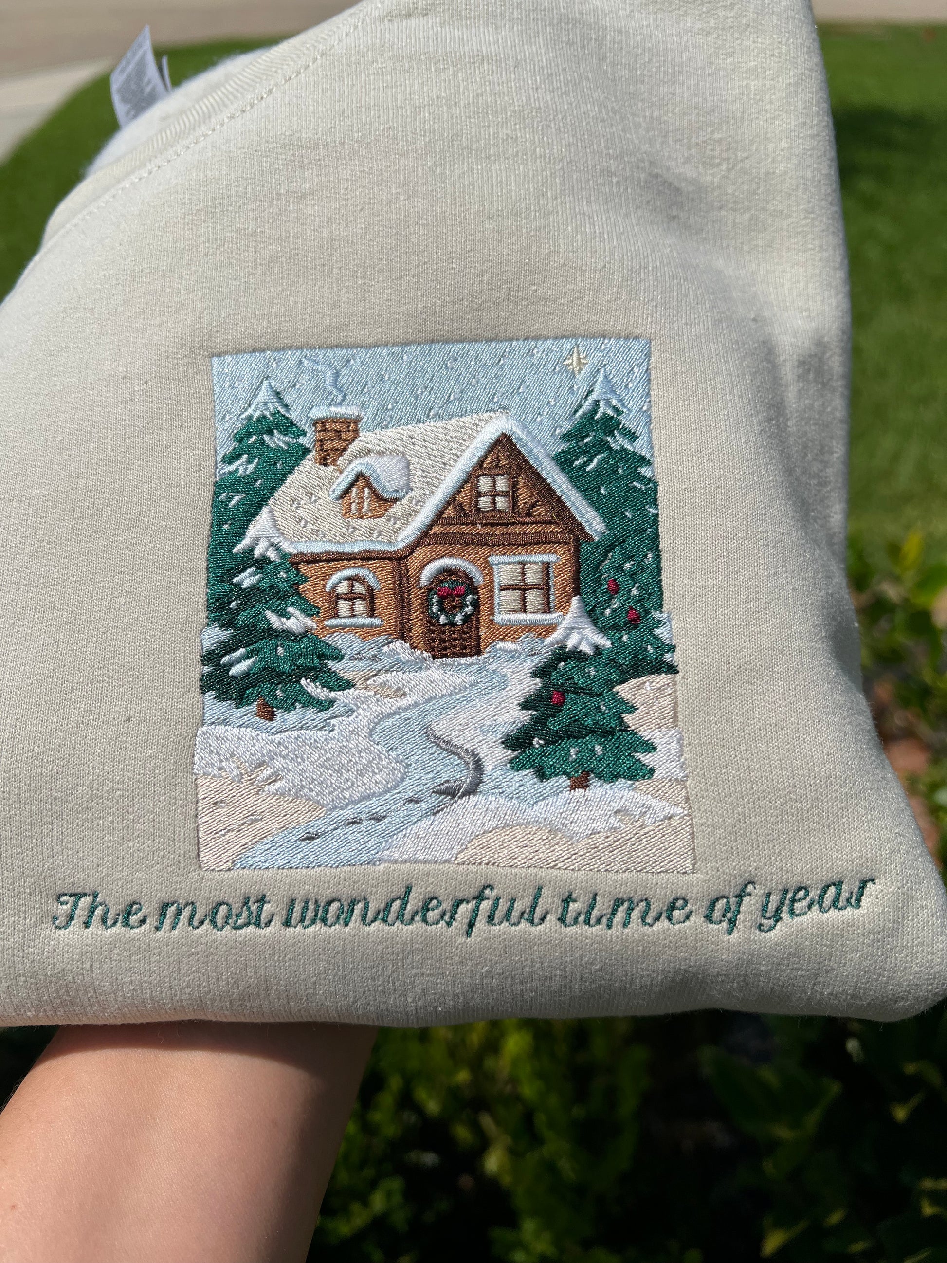 Embroidered Crewneck -with the words "The most wonderful time of year below a snowy scenic cabin