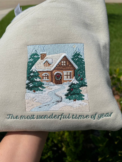 Embroidered Crewneck -with the words "The most wonderful time of year below a snowy scenic cabin