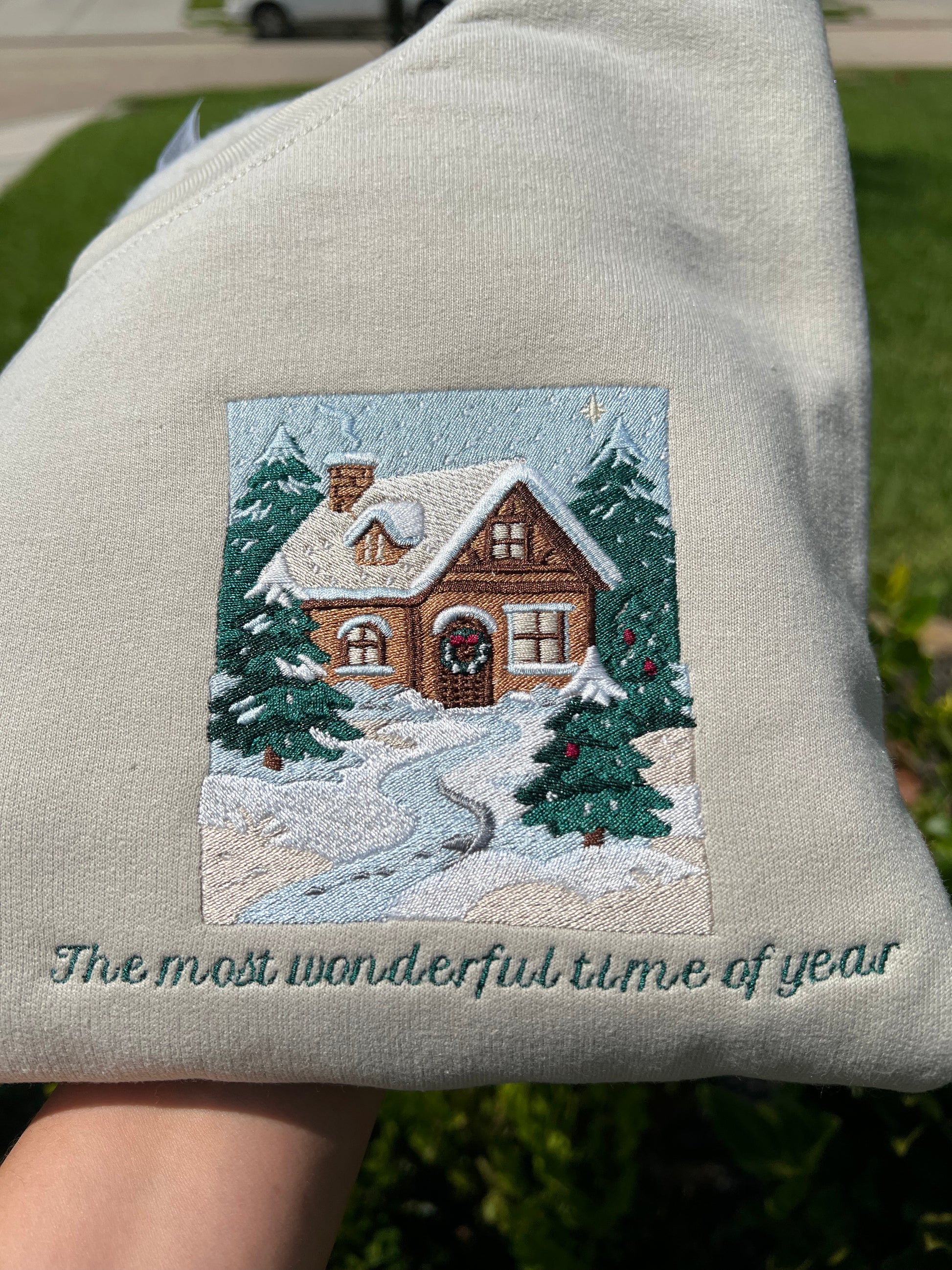 Embroidered Crewneck -with the words "The most wonderful time of year below a snowy scenic cabin