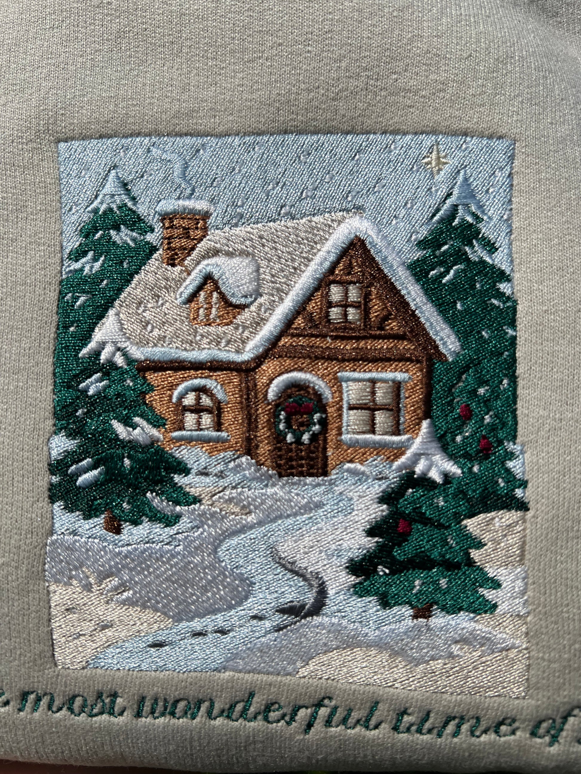 Embroidered Crewneck -with the words "The most wonderful time of year below a snowy scenic cabin