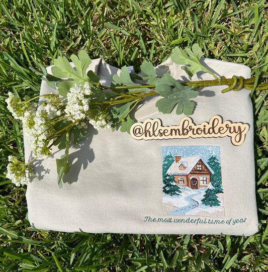 Embroidered Crewneck -with the words "The most wonderful time of year below a snowy scenic cabin