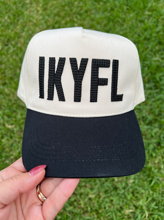 beige and black cap with centered crossed puff font. 