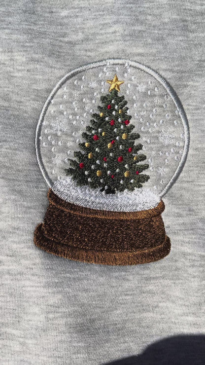 Gray sweatshirt with a Christmas tree snow globe design on a gray background