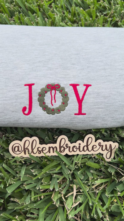 gray sweatshirt with 'JOY' and a wreath design 
