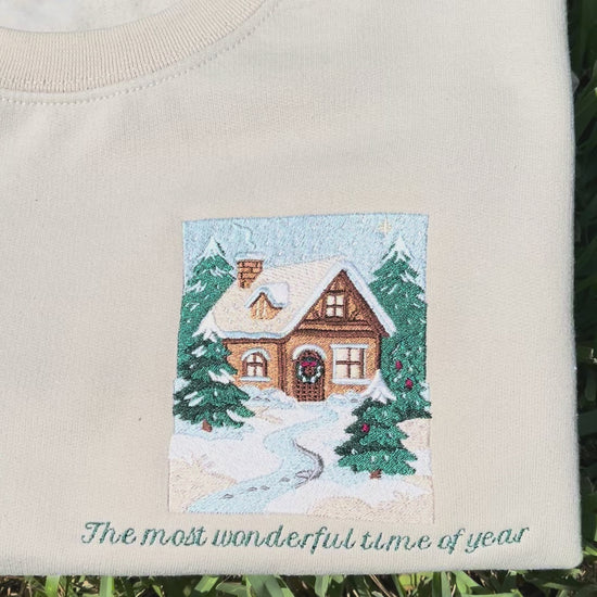 Embroidered Crewneck -with the words "The most wonderful time of year below a snowy scenic cabin